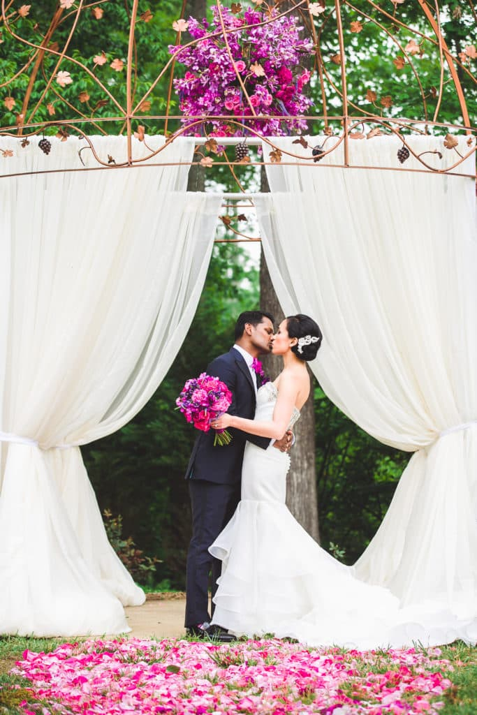 SUMMER-WEDDING-COUPLE-KISS-CEREMONY-FLOWERS-WINERY-WEDDING-POTOMAC-POINT-VIRGINIA- Potomac Point Winery & Vineyard