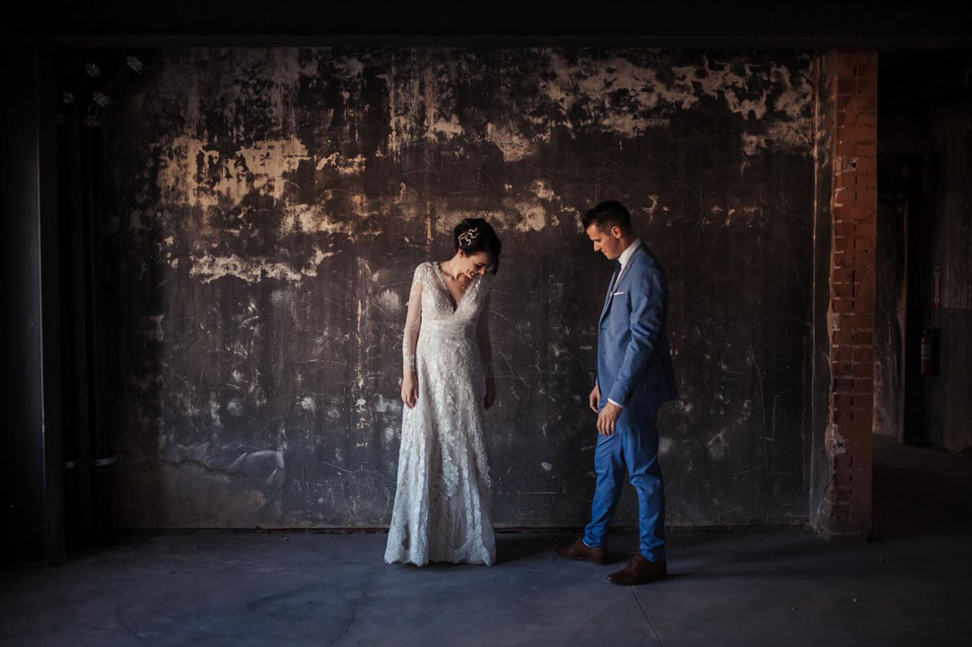 couple standing together with rustic backdrop on wedding day