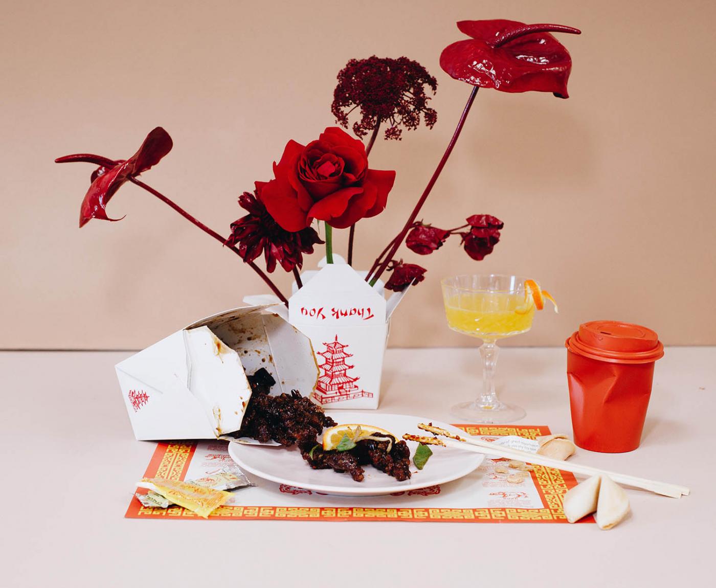 chinese takeout meal with drink and red flowers