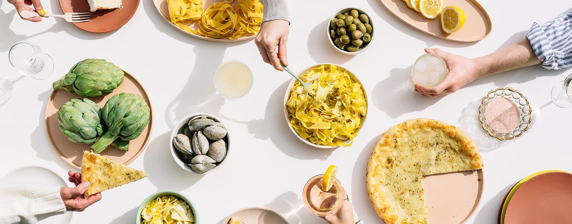 A shared table laid out with food and drinks for a group gathering