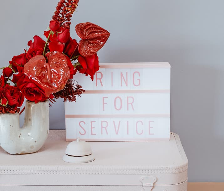 Ring for service light box beside a vase of red flowers